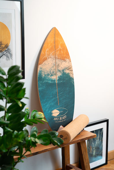 Balance Board im Surfstyle und Wellen deck steht zuhause auf kleiner Holzbank dekorativ